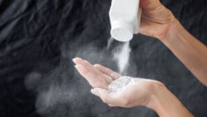 person-pouring-powder-from-a-bottle-into-their-hand