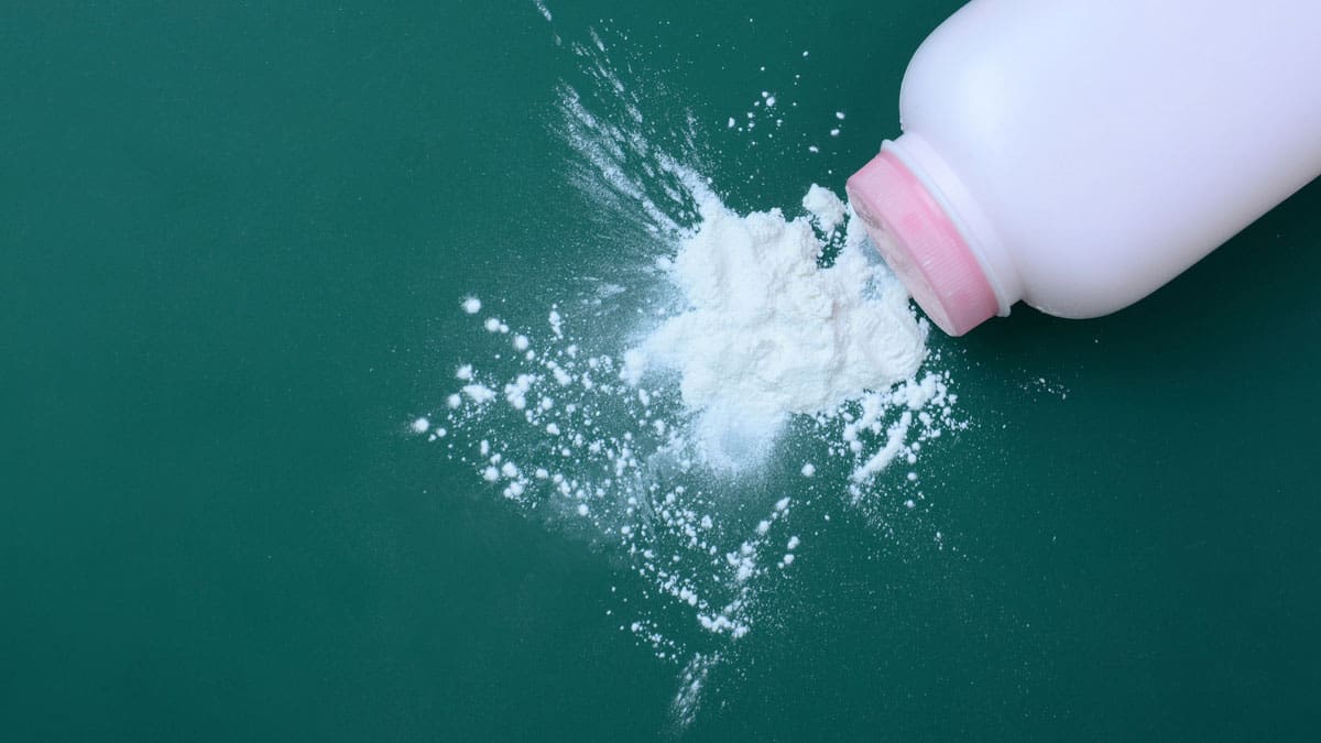 powder-spraying-from-a-bottle-against-a-dark-green-background