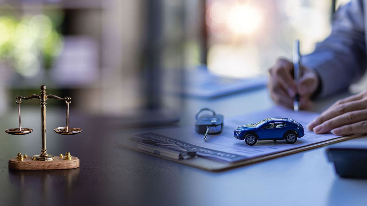 scales-of-justice-and-toy-cars-on-a-desk-while-someone-writes