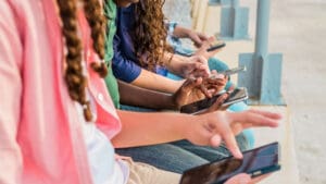 side-view-of-a-row-of-teens-on-cell-phones
