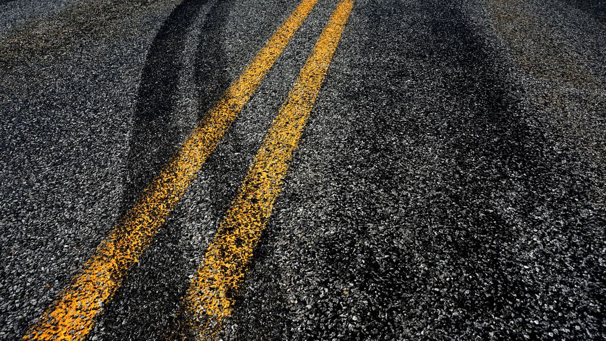 skid-marks-across-a-yellow-center-line-on-a-road