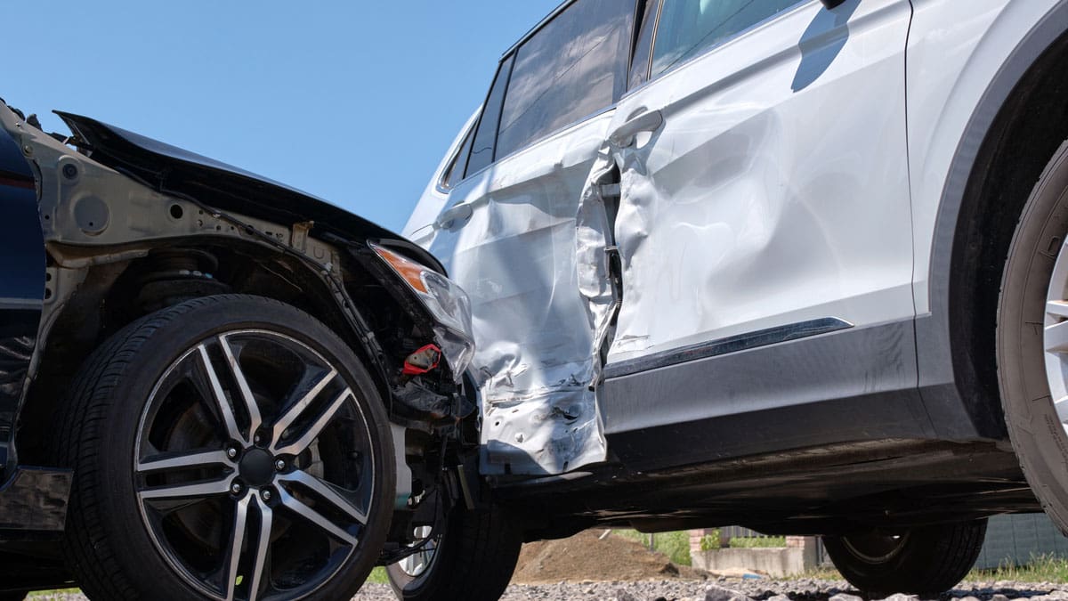 white-SUV-with-heavy-front-end-damage-at-the-roadside
