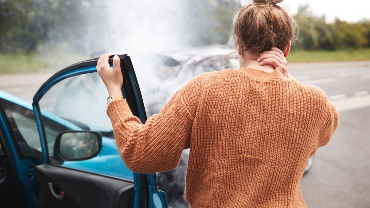 woman-on-her-phone-beside-a-smoking-car-at-the-roadside