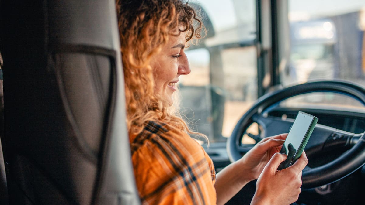 woman-using-her-phone-while-sitting-behind-the-wheel
