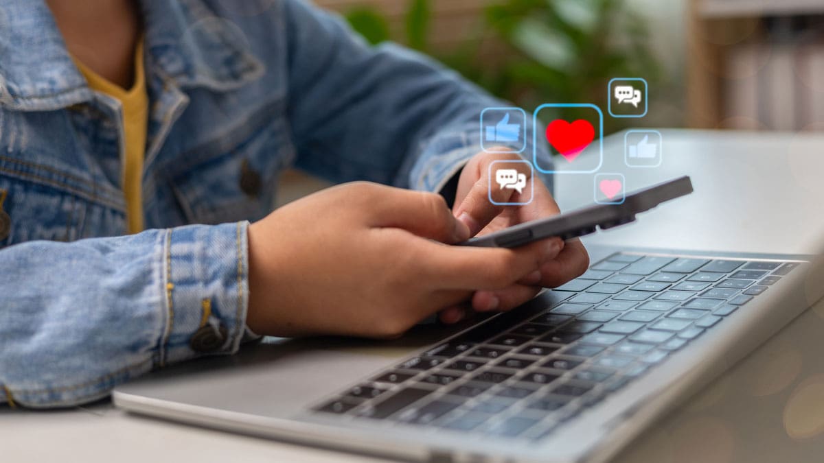 young-person-sitting-with-laptop-on-cell-phone
