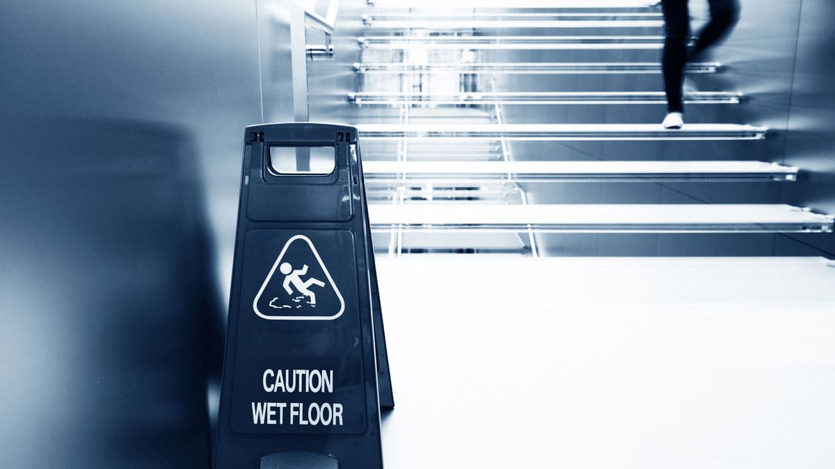 caution-wet-floor-sign-at-the-bottom-of-a-staircase
