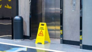 caution-wet-floor-sign-near-an-elevator-in-a-parking-garage