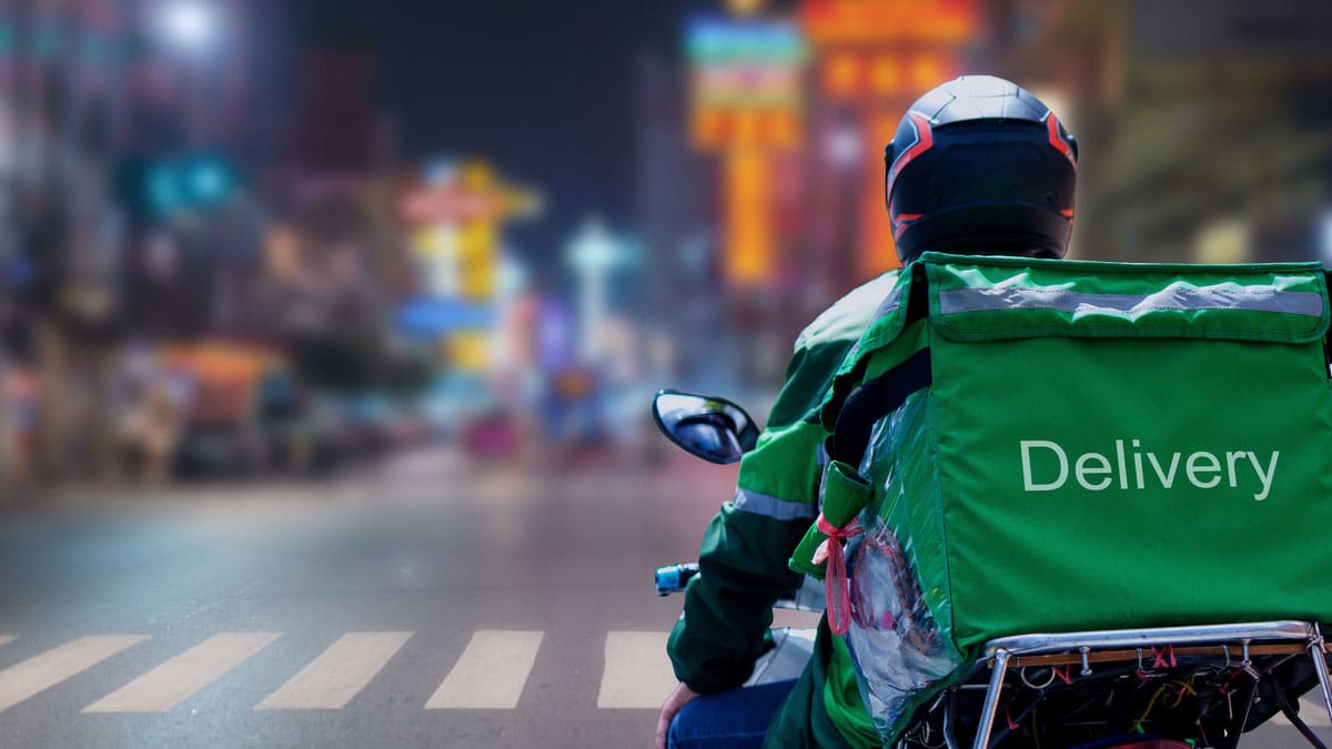 delivery-rider-on-a-scooter-with-an-insulated-backpack-at-night