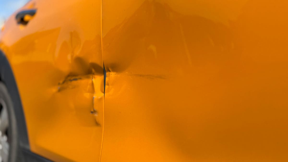 dented-panel-on-an-orange-car