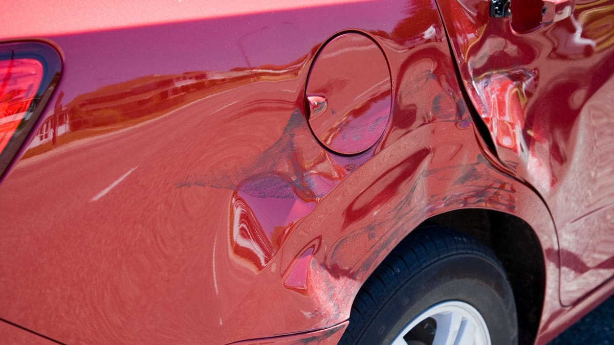 dented-rear-quarter-panel-on-a-red-car