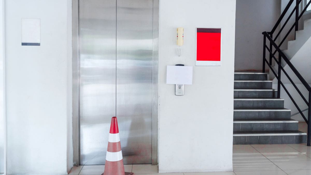 elevator-doors-in-a-building-lobby-with-a-caution-cone-nearby
