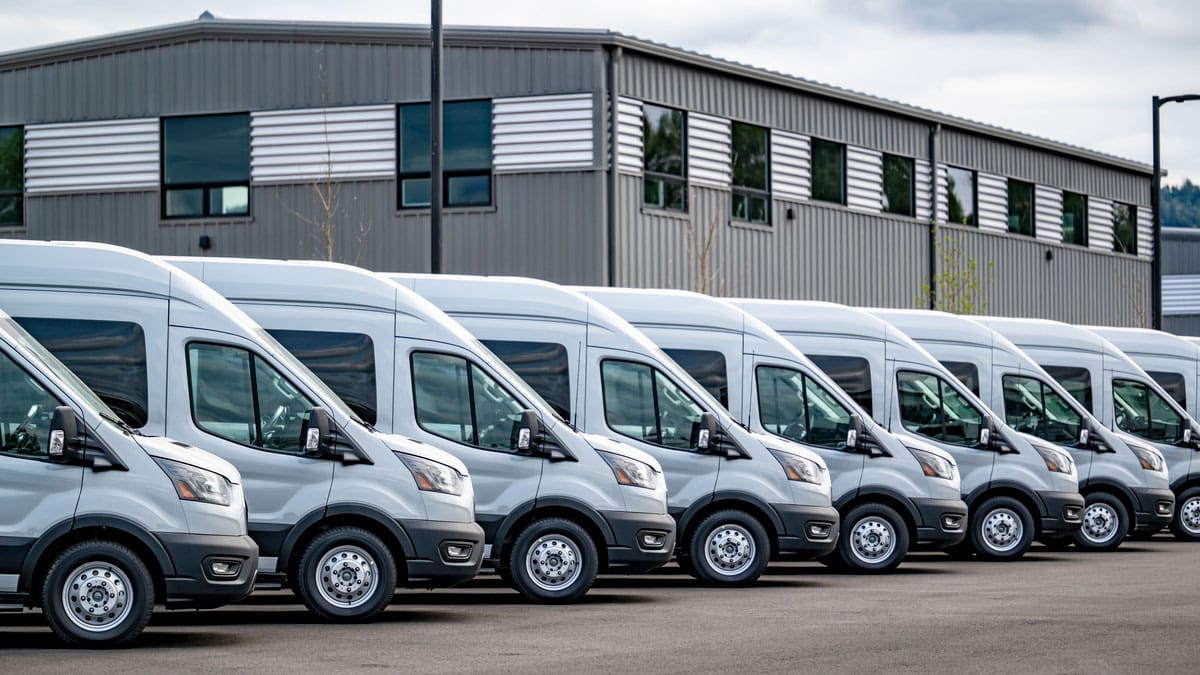 fleet-of-white-delivery-vans-parked-outside-a-warehouse