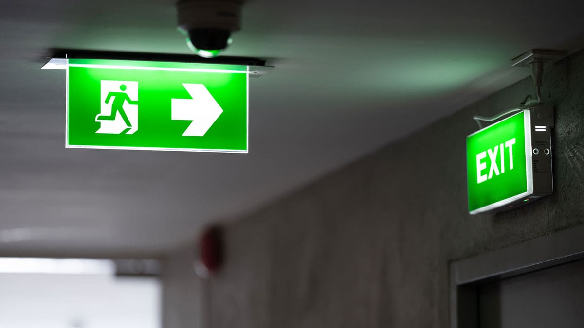 illuminated-emergency-exit-signs-in-a-building-hallway