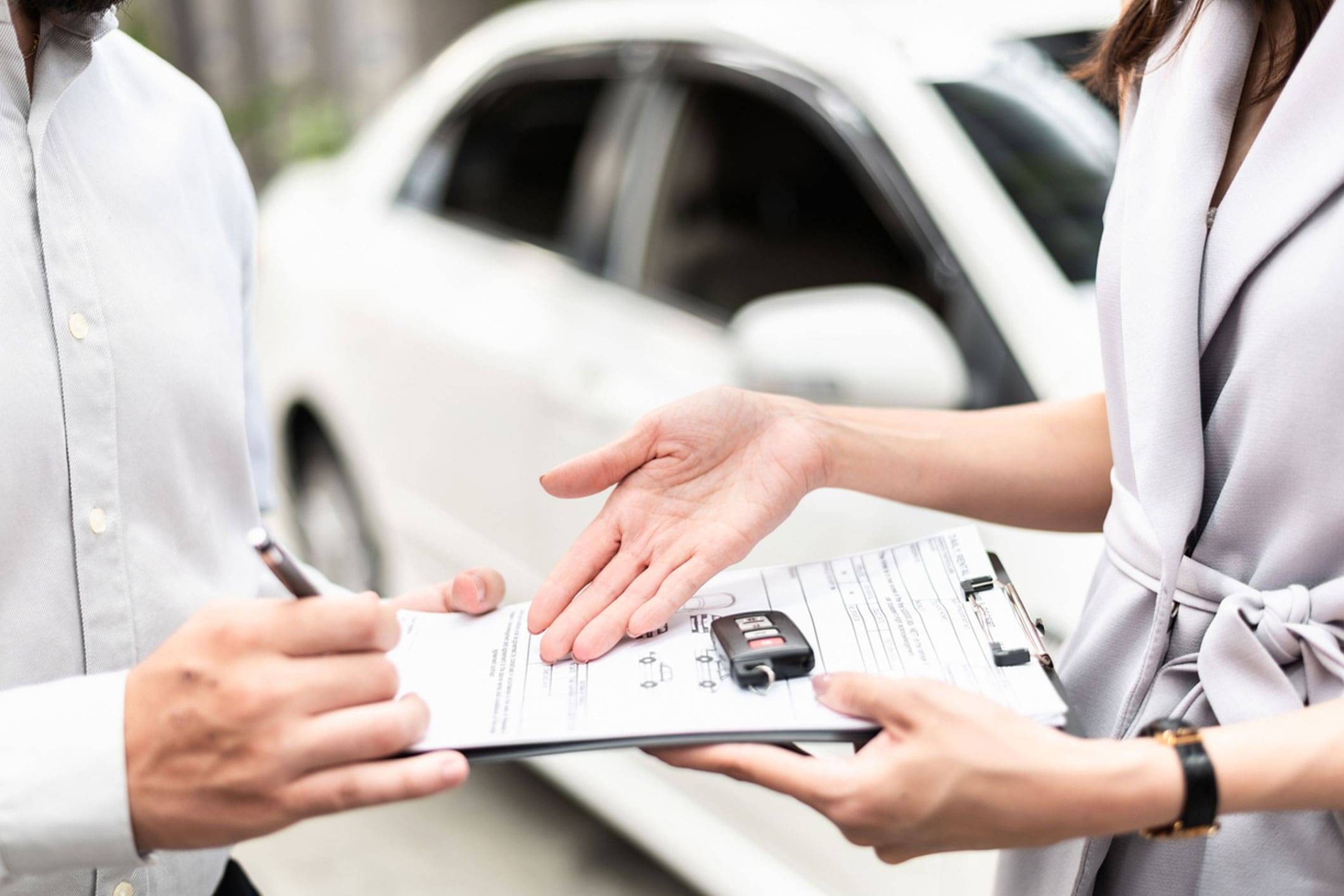 insurance-adjuster-filling-out-a-form-beside-a-damaged-car