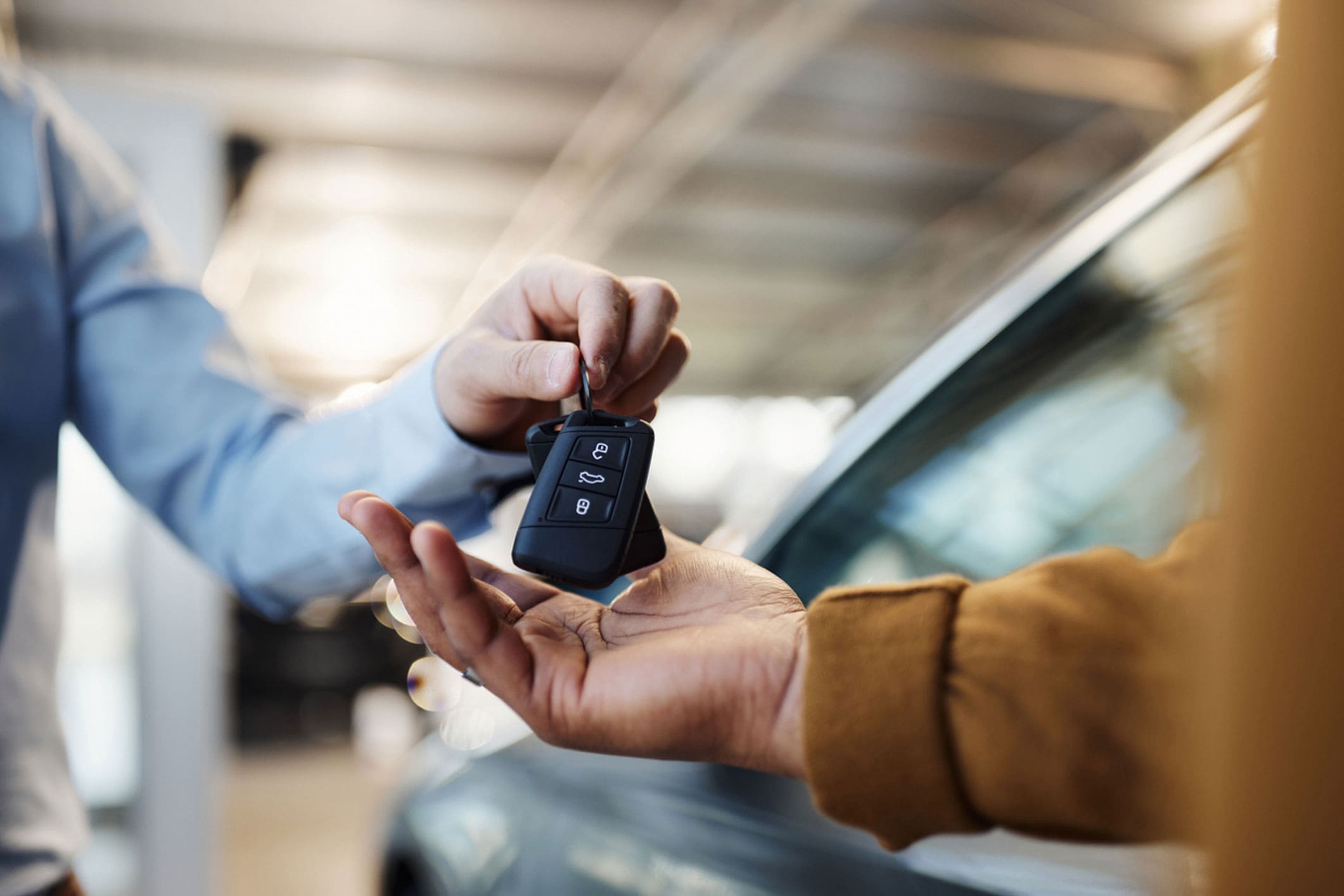 person-handing-car-keys-to-another-person