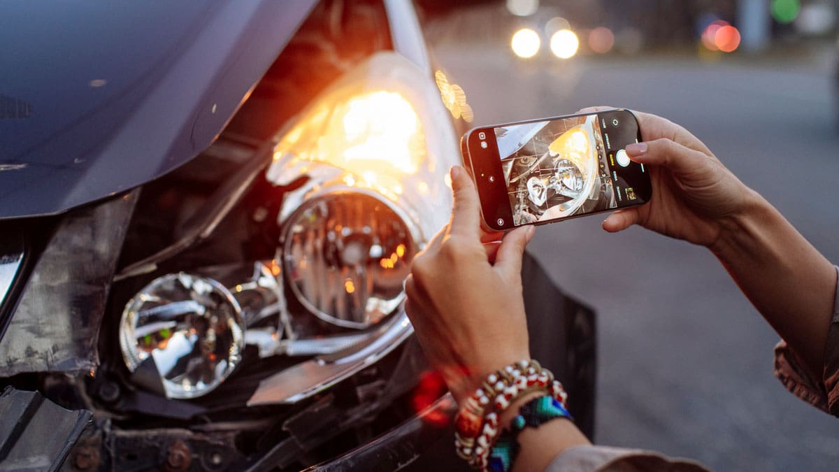 person-inspecting-the-damaged-engine-bay-of-a-car
