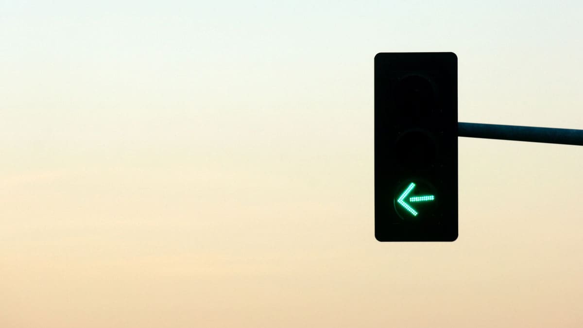 traffic-signal-showing-a-green-left-turn-arrow-against-a-pale-sky