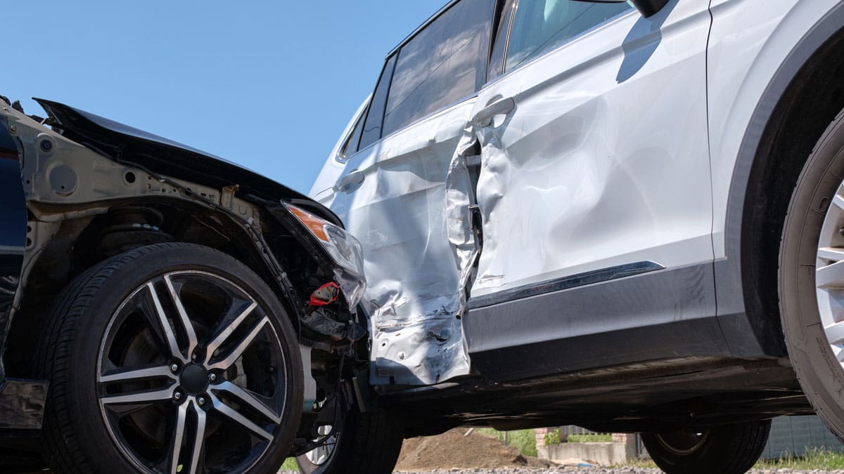 white-SUV-with-heavy-front-end-damage-at-the-roadside