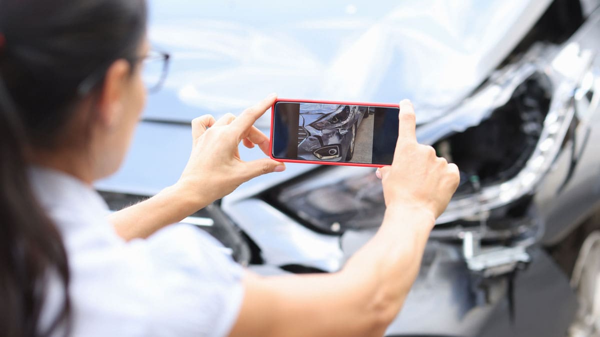 woman-photographing-damage-to-a-car-with-her-phone