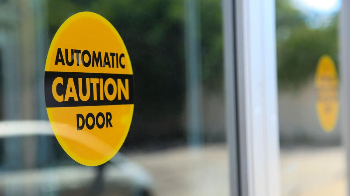 yellow-caution-sign-on-automatic-door