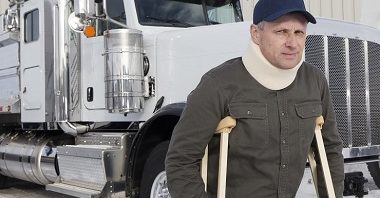 A royalty free image from the trucking industry of a truck driver on crutches.